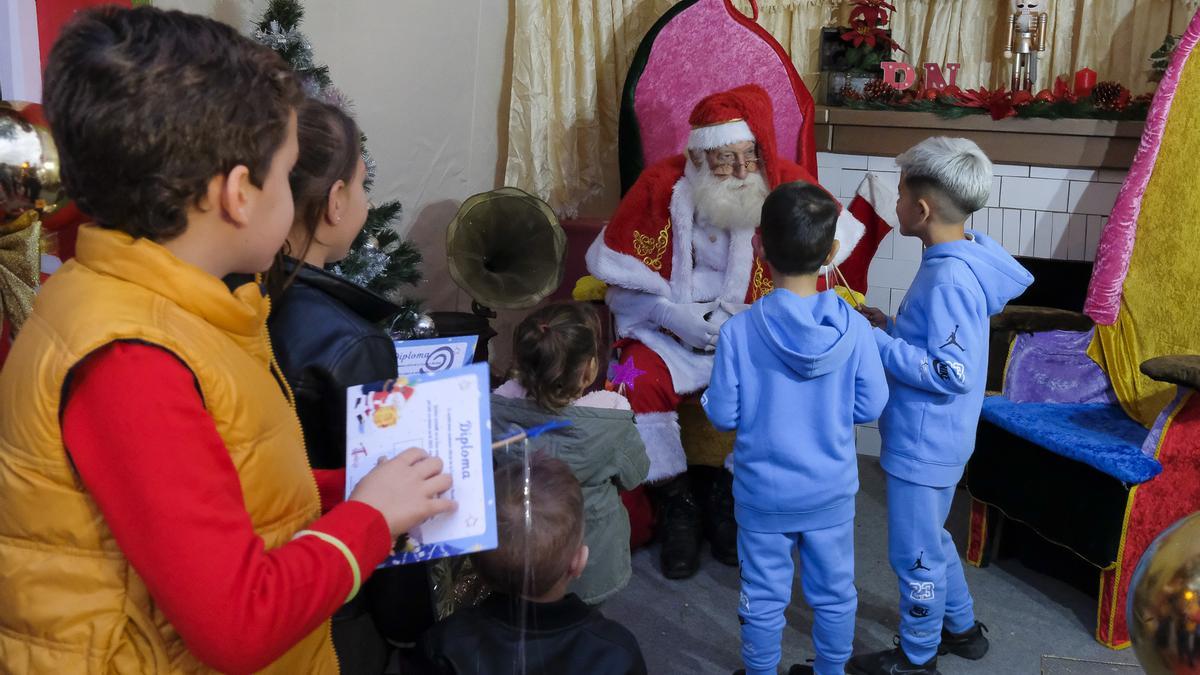 Un grupo de niños saludan a Papá Noel en la Casa de la Navidad de Telde