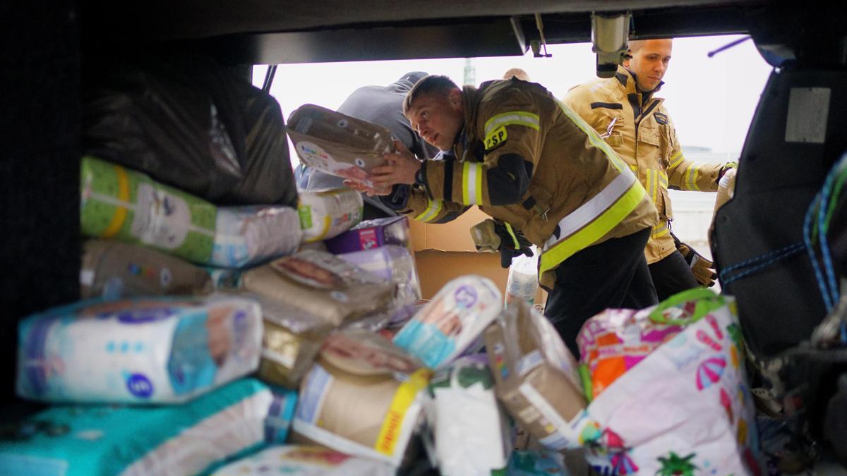 Polonia, Przemysl: Un guardia carga suministros de ayuda en un autobús propiedad del voluntario británico Cliff Wilson, quien lo transportará desde Przemysl en Polonia a Ucrania 