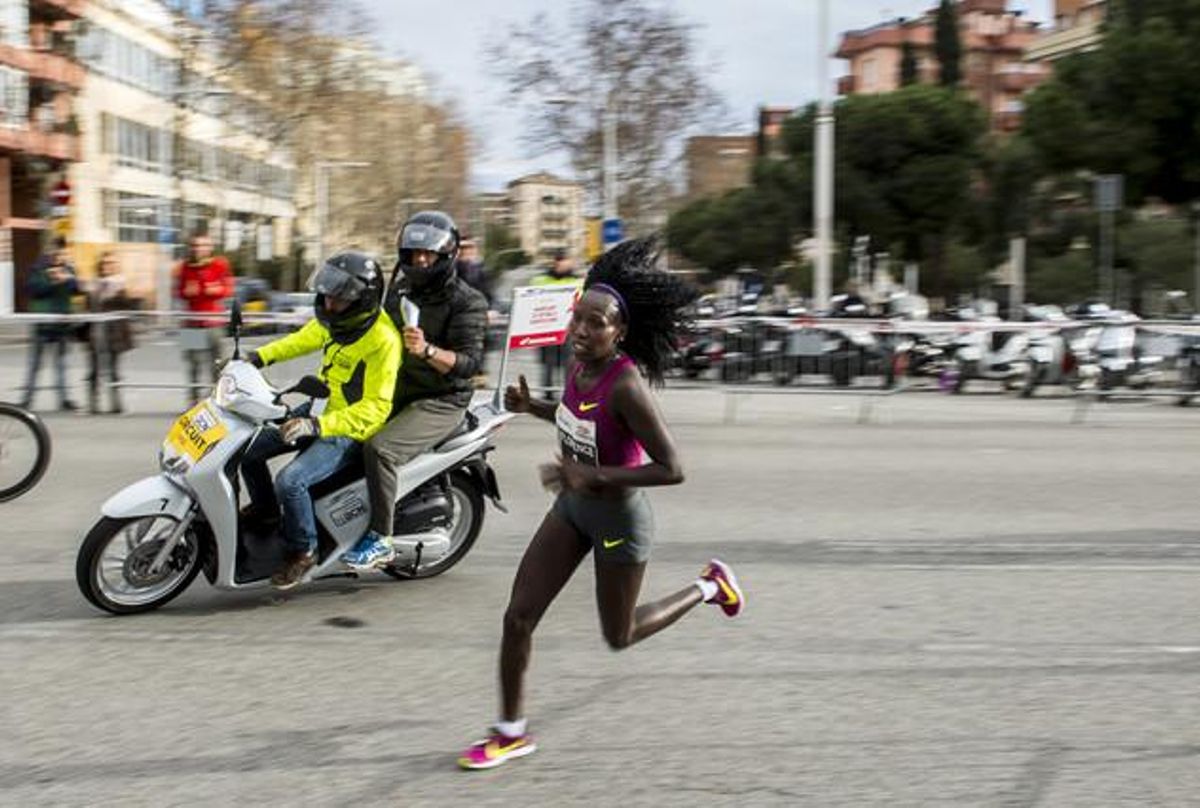 L’atleta kenyana Florence Kiplagat traça l’últim revolt per recórrer els últims metres i establir una nova plusmarca mundial de mitja marató a Barcelona. L’atleta kenyana Florence Kiplagat traça l’últim revolt per recórrer els últims metres i establir una nova plusmarca mundial de mitja marató a Barcelona.