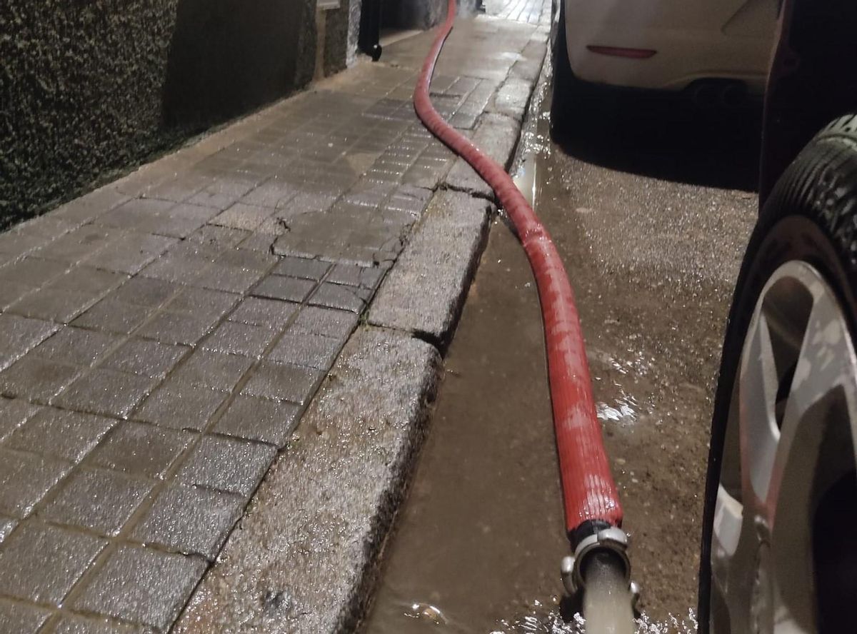 Los Bomberos achican el agua acumulada en una bodega de la calle Dominicos