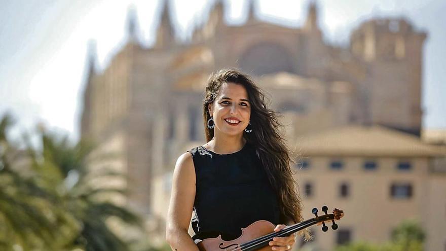 Ali Domínguez posa con su violín con la catedral de fondo.