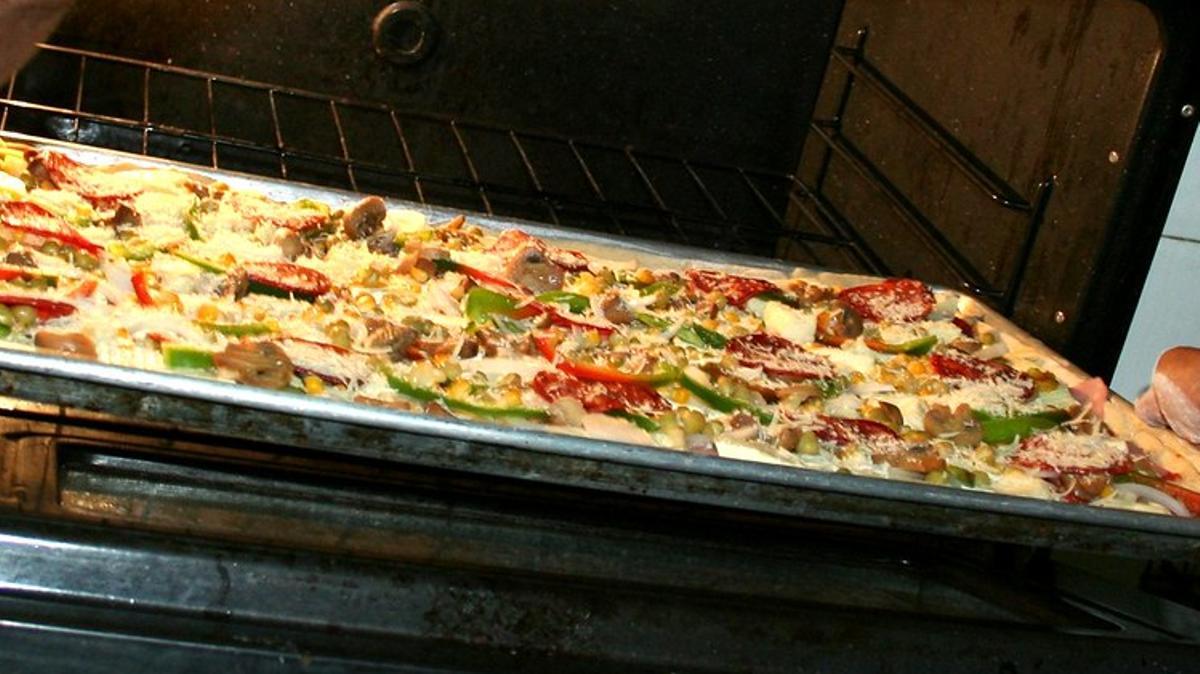 Pizza entrando dentro del horno de casa.