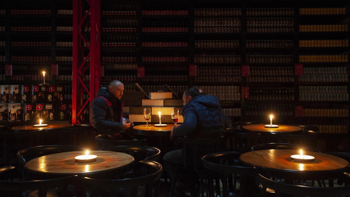 Clientes visitan un restaurante iluminado con velas en la ciudad de Leópolis, Ucrania.