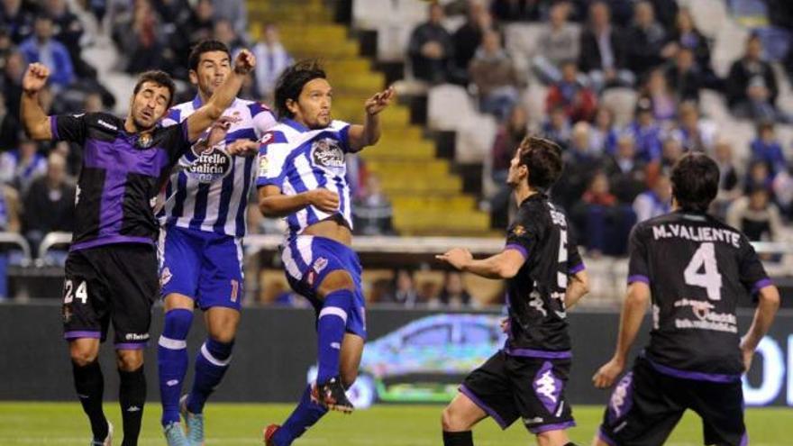 Abel Aguilar salta por un balón, ante tres defensas y con Riki por detrás. / juan varela