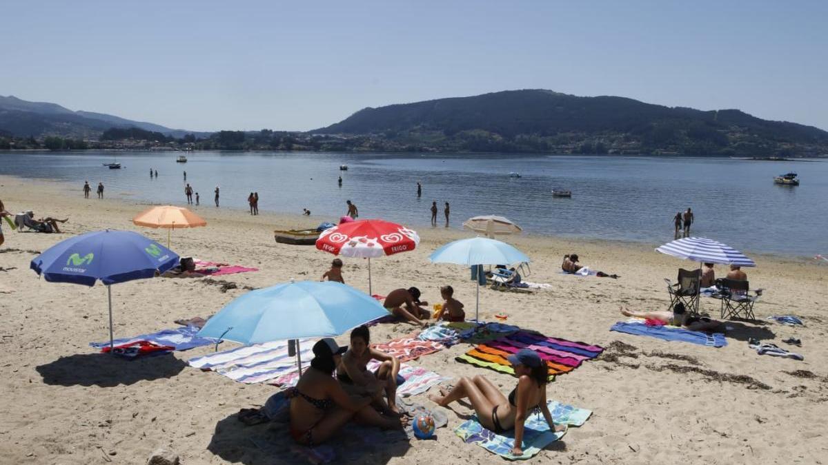 Bañistas este mediodía en la playa de Cesantes. // Alba Villar