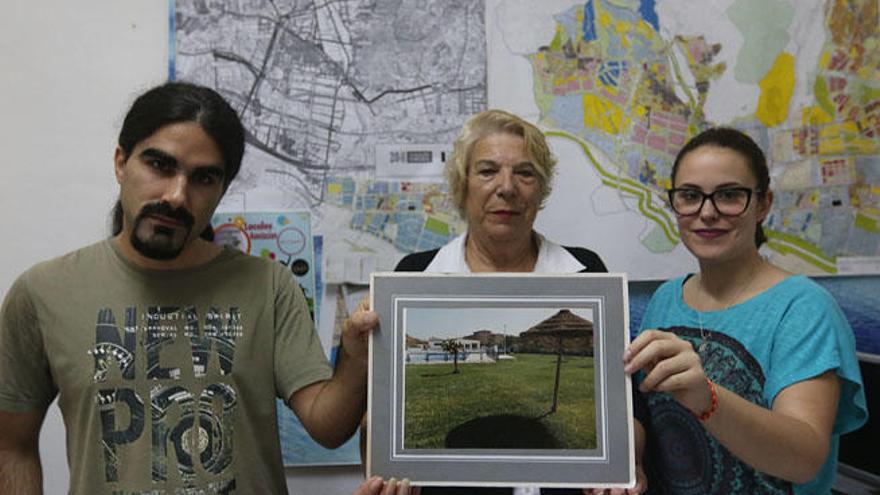 La presidenta vecinal, Carmela Fernández, con Carmen Santana y Álvaro Cortés, con una antigua foto de la piscina de Campanillas.