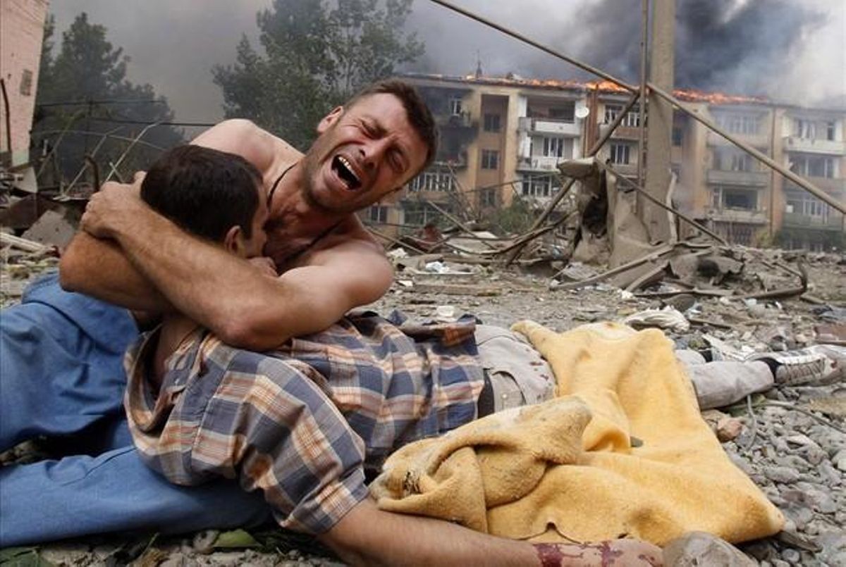 A Georgian man cries as he holds the body of his relative after a bombardment in Gori, 80 km (50 miles) from Tbilisi in this August 9, 2008 file photo.