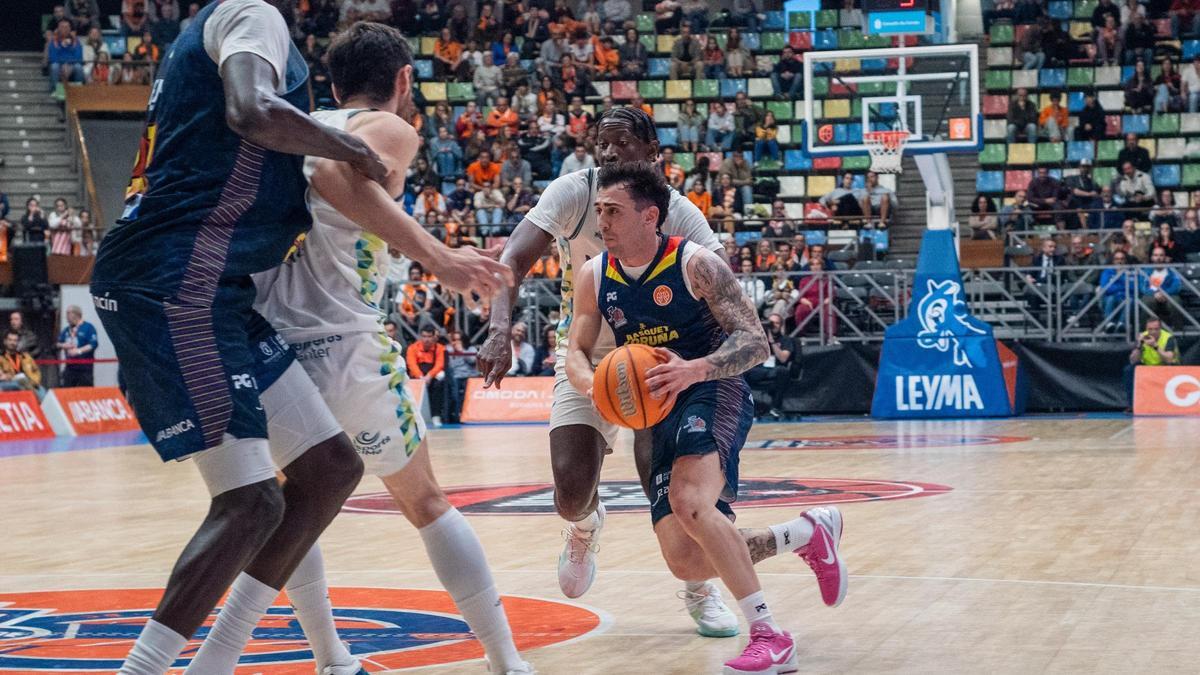 Dídac Cuevas encara a dos jugadores del Menorca en el duelo de la liga regular en el Coliseum.