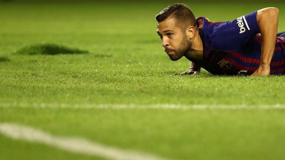 Jordi Alba, tendido en un césped en pésimo estado.