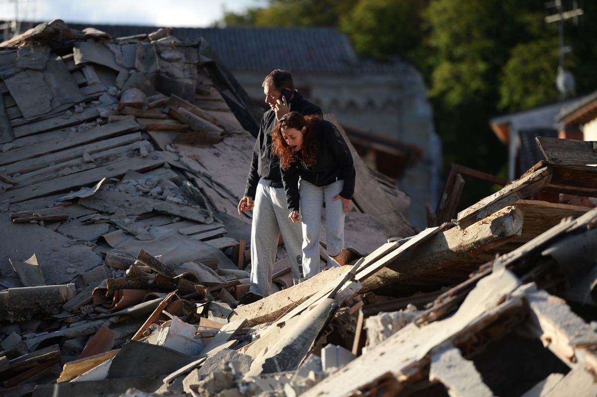 Algunos habitantes de Amatrice, entre los escombros tras el terremoto.