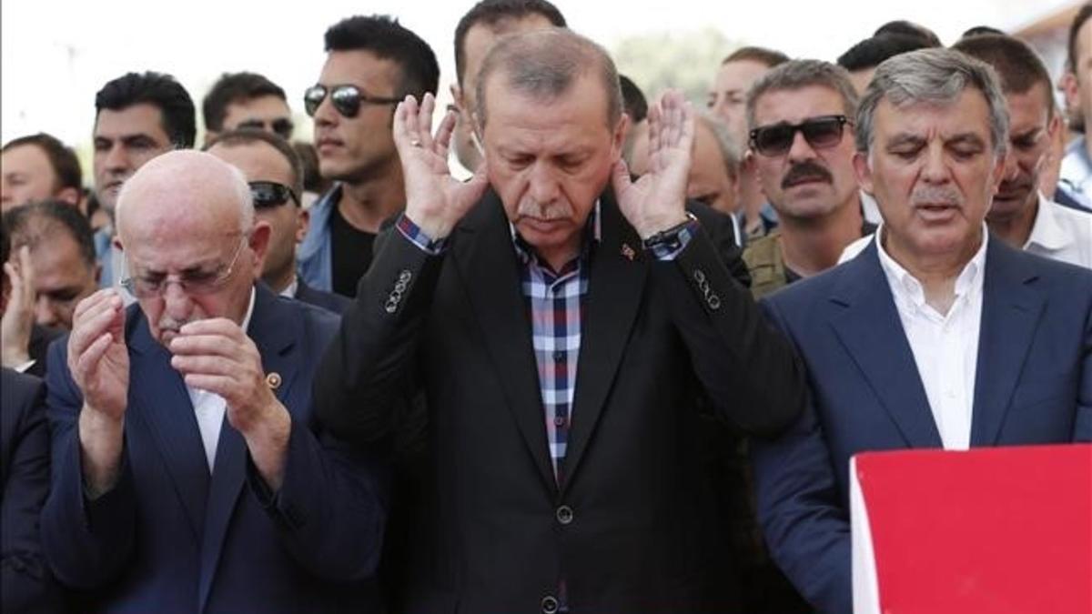 Erdogan reza junto al expresidente turco Abdulá Gul (derecha).