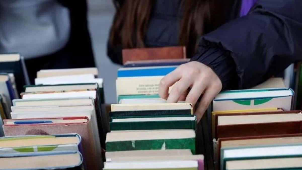 Un joven ojeando libros.