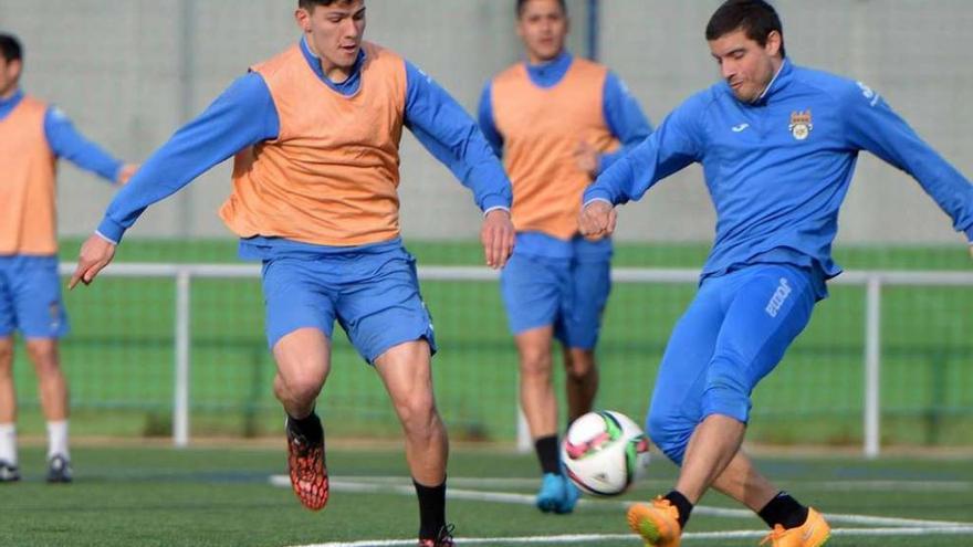 Miguel Loureiro le disputa un balón a su compañero de posición, Adrián, durante un entrenamiento. // G. Santos