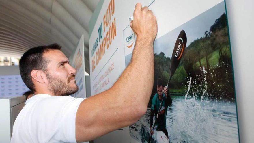 Saúl Craviotto deja su firma en un póster en el transcurso de un acto publicitario celebrado ayer en Gijón.