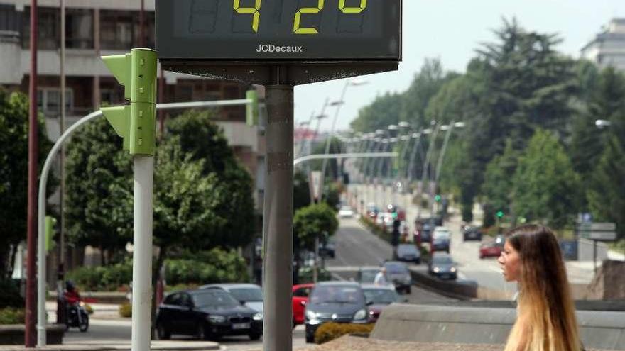 Una joven pasea por la calle mientras el termómetro marca más de 40 grados.