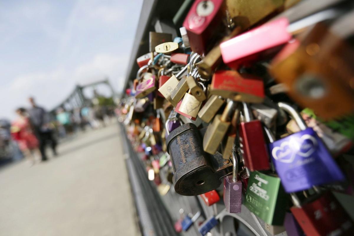 DEN04. Frankfurt (Germany), 07/09/2014.- German and foreign nationals walk past so-called ’Love Locks’ which are fixed at the Eiserner Steg bridge in Frankfurt/Main, Germany, 07 September 2014. The locks are fixed at the rails of the bridge by Lovers as a symbol of their enduring love. It is speculated that the tradition of putting locks symbolizing a couple’s love on bridges was started by a book ’I Want You’ by Federico Moccia in Rome. To date, some 10 countries practice the tradition, including France, Germany, China, South Korea, Sweden, Ireland, United Kingdom, Australia, Uruguay, and Malta. (Francia, Suecia, Francia, Alemania) EFE/EPA/DENNIS M. SABANGAN
