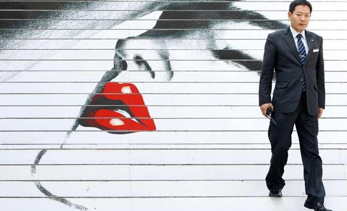 Un home baixa una escala pintada amb motius de l’òpera Tosca, de Giacomo Puccini, que es representarà al Sejong Center de Seül, Corea del Sud.