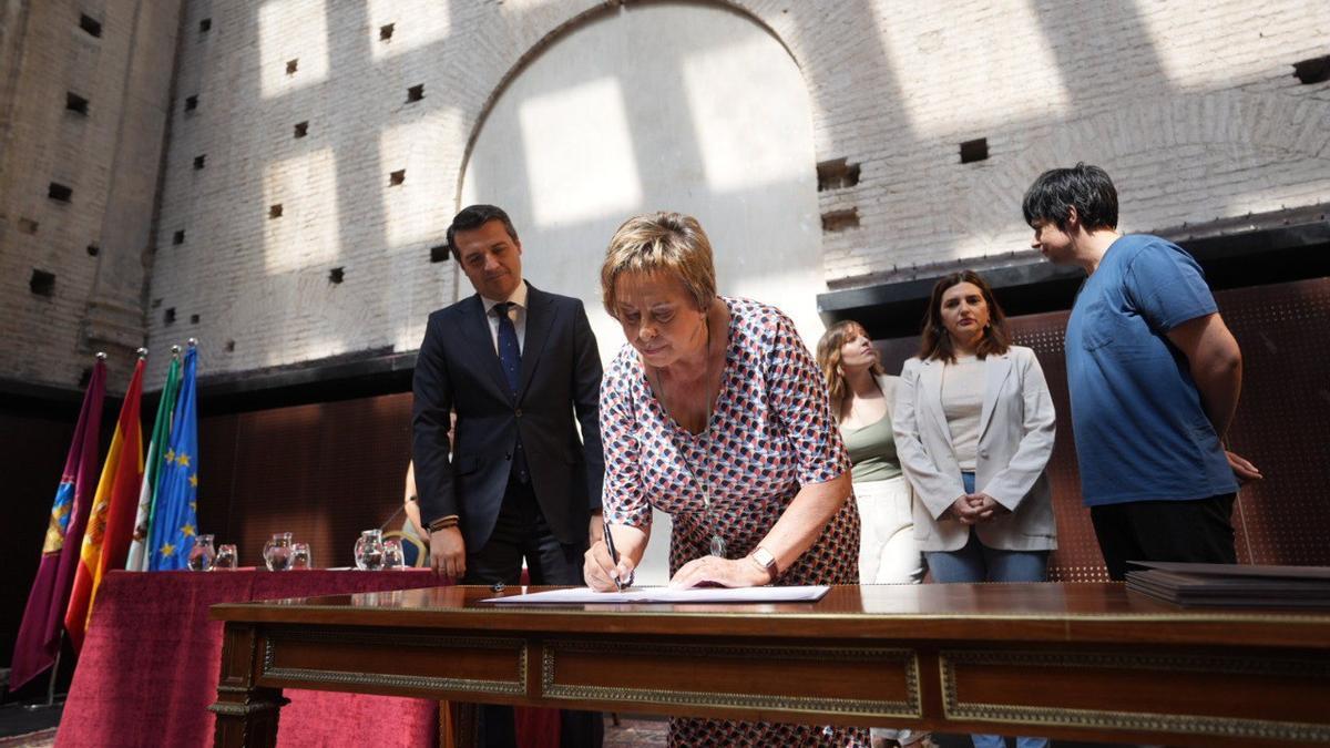 La viuda de Julio Anguita, Agustina Martín, firma el protocolo de cesión del archivo.
