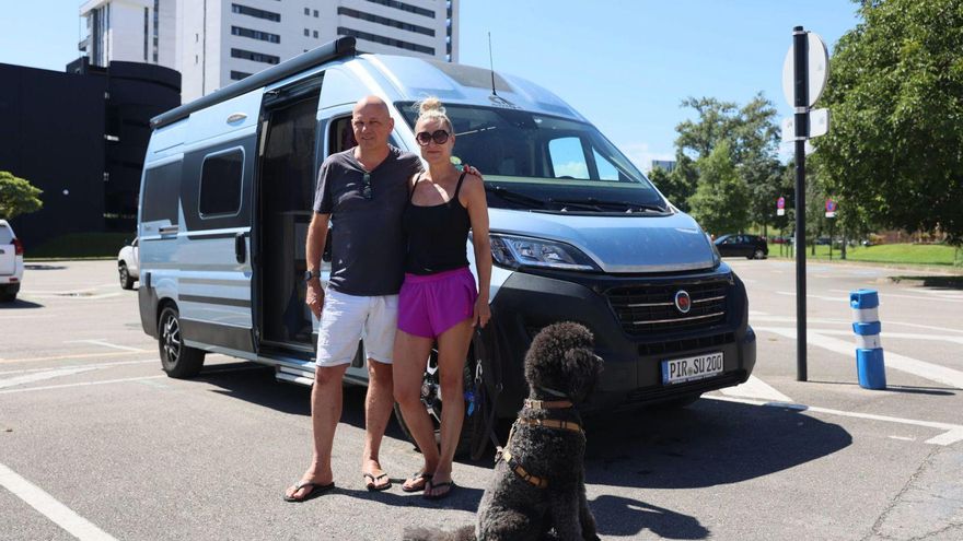 Joachim Krieg y su mujer posan junto a su perro en el área de autocaravanas de La Corredoria. | MARIO CANTELI