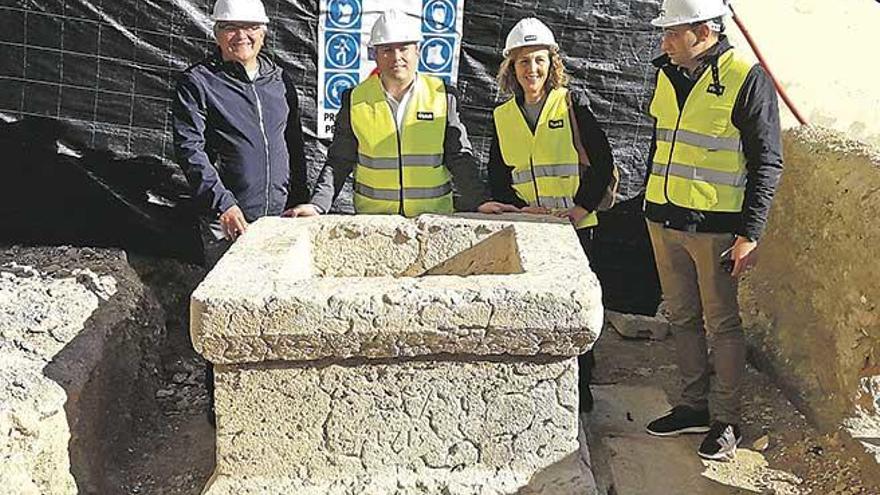 El alcalde y algunos concejales junto al brocal del antiguo pozo descubierto durante las obras.