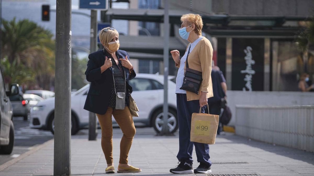 Dos mujeres con mascarilla hablan en una calle de Santa Cruz de Tenerife.