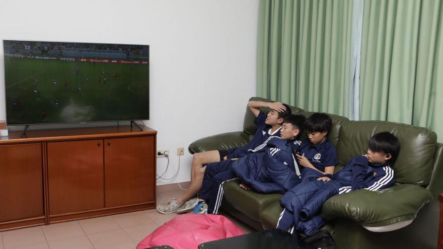 Los japoneses de la cantera del Oviedo, ayer viendo el partido de Japón contra España. | Fernando Rodríguez