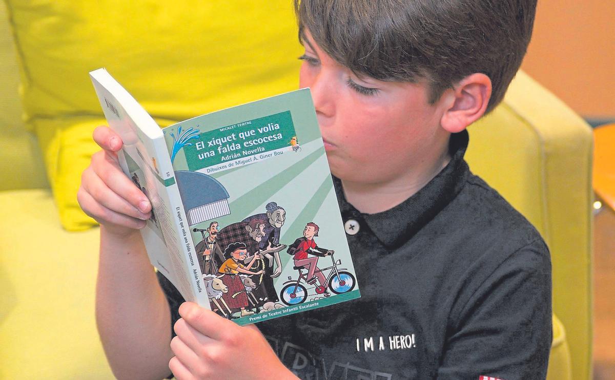 Un xiquet llegint un llibre de la col·lecció ‘Micalet Teatre’, d’Edicions Bromera