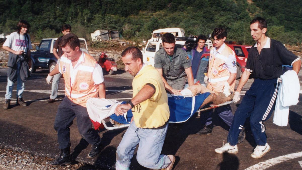 Varias personas socorren a una víctima de la riada en Biescas, el 7 de agosto de 1996.