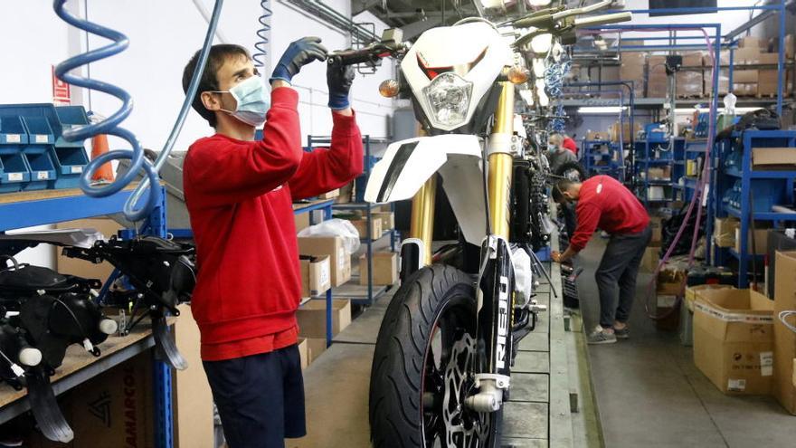 Un treballador de Rieju muntant una moto a la cadena de muntatge de la fàbrica de Figueres