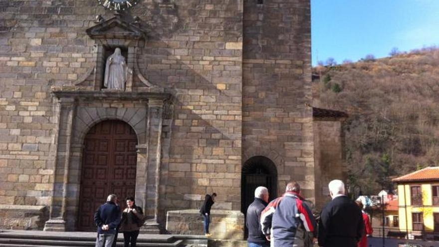 nuevo sistema y nuevo aspecto. A la izquierda, varios vecinos, delante de la basílica de Cangas, con el reloj con la esfera pintada en negro y los números de bronce. Sobre estas líneas, la antigua maquinaria retirada.