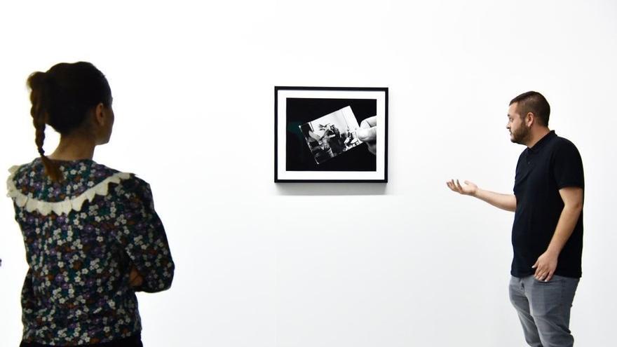 El artista pacense Abel Jaramillo junto a una de las fotografías de la exposición de la Sala Europa.
