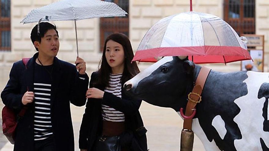 Turistas bajo la lluvia en la capital.