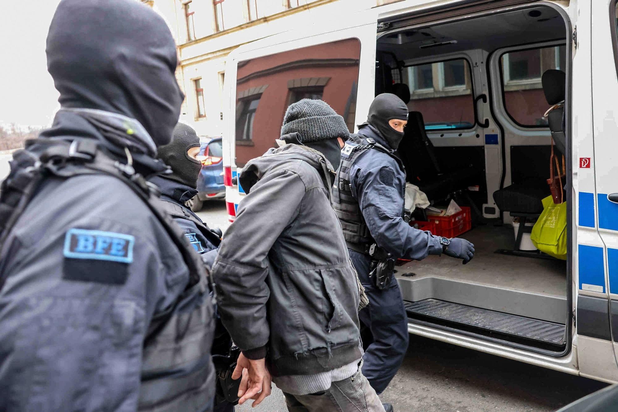 Agentes de policía sacan a un sospechoso del intento de asesinato al ministro principal de Sajonia de un edificio residencial en Dresde.