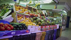 Un estante de hortalizas y frutas en un mercado.