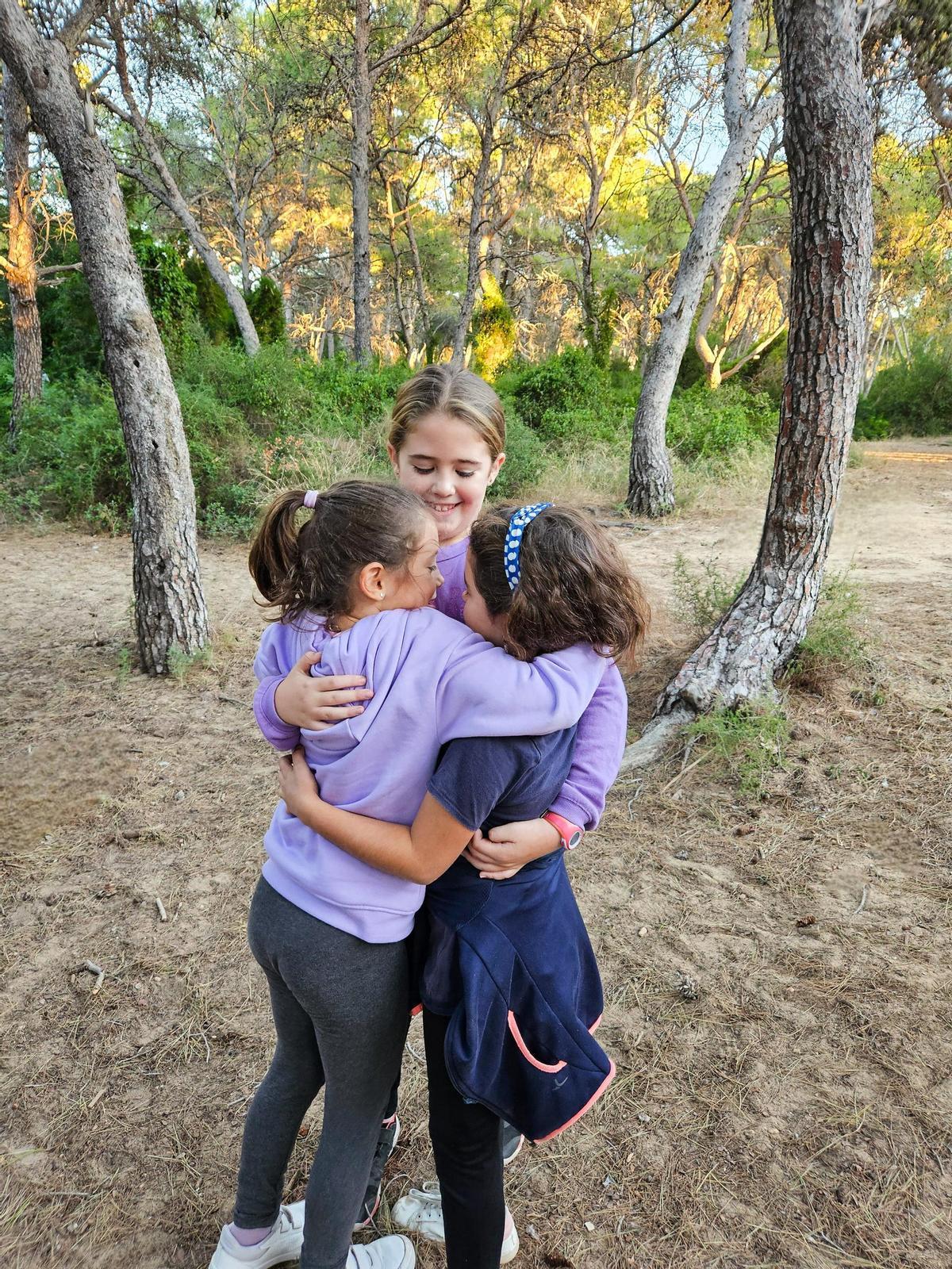 Alumnes jugant en la pinada d'enfront de l'escola