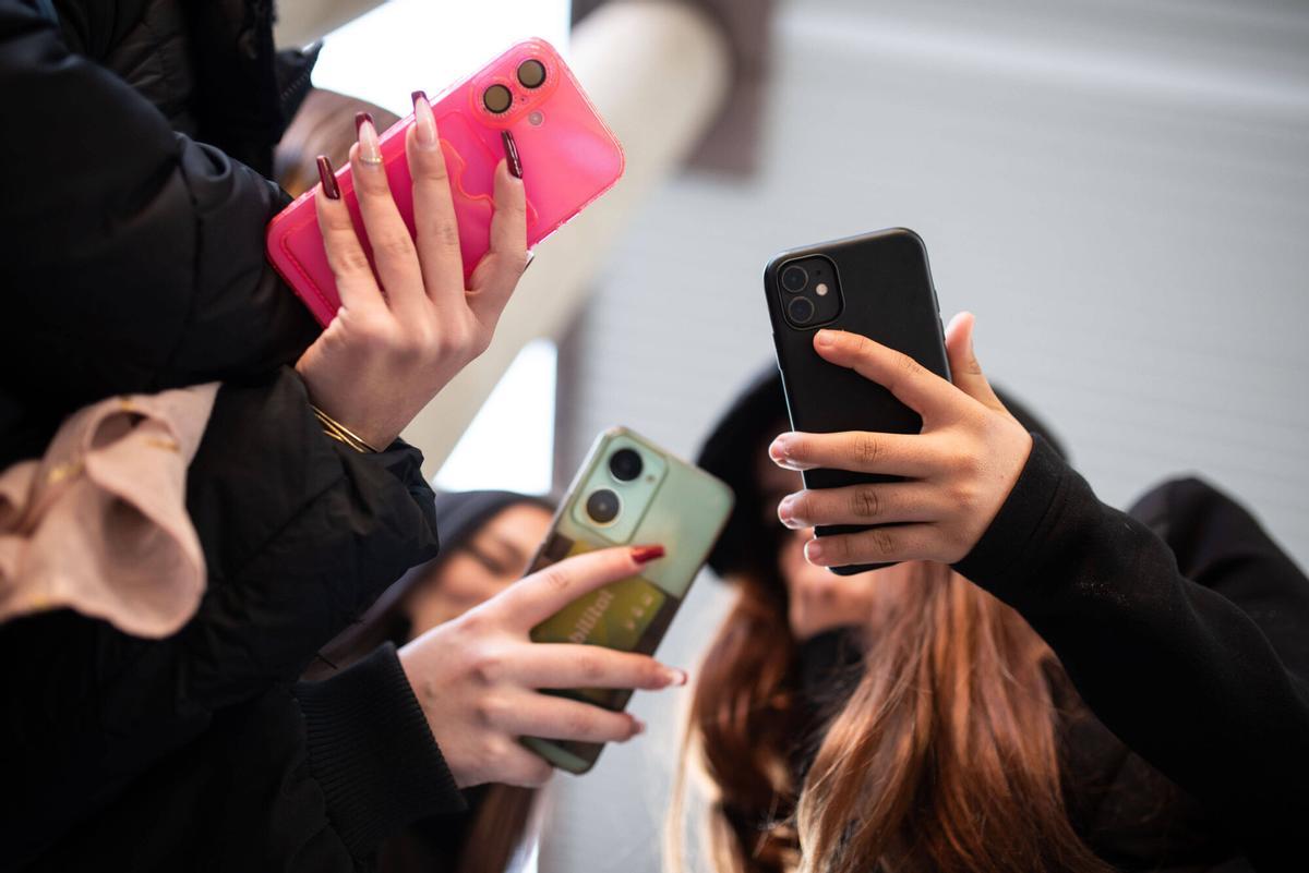 Unos jóvenes usan unos móviles con funda, en una imagen de archivo.