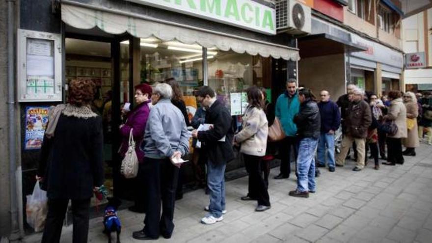 Pacientes hacen cola a las puertas de una farmacia de Alicante durante la huelga de dos días del pasado mes de diciembre.