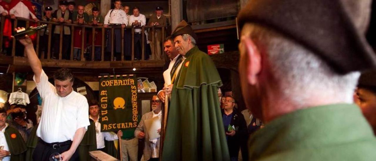 El escanciador Antonio Pérez echa un culete en el Museo de la Sidra rodeado de la Cofradía de Siceratores.