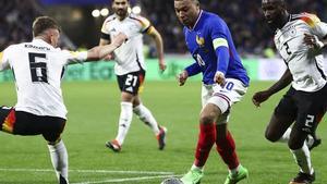 Kylian Mbappé, jugador de la selección francesa, encara a Kimmich, de Alemania, con Rüdiger al fondo.