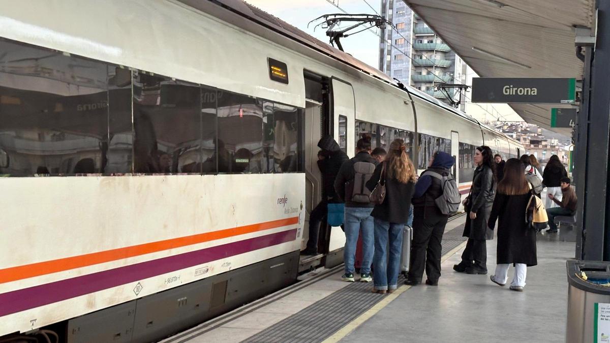 Passatgers entrant al tren de Rodalies, a l'estació de Girona, en una imatge d'arxiu.