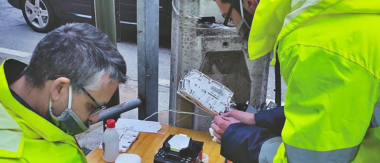 Alumnos del Obradoiro instalando fibra óptica en un punto de Vilanova de Arousa. |   // CEDIDA