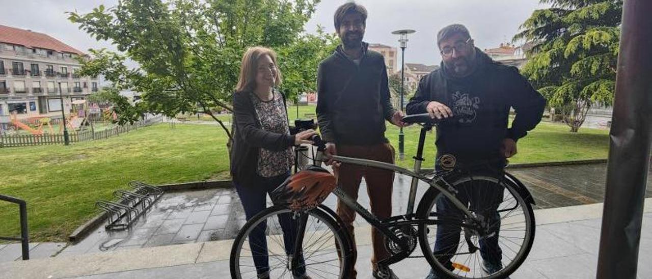 Los ediles Dolores Chapela, Rodrigo Currás y Daniel Costas, con la bicicleta que usa el segundo para ir al Concello.   | G.N.