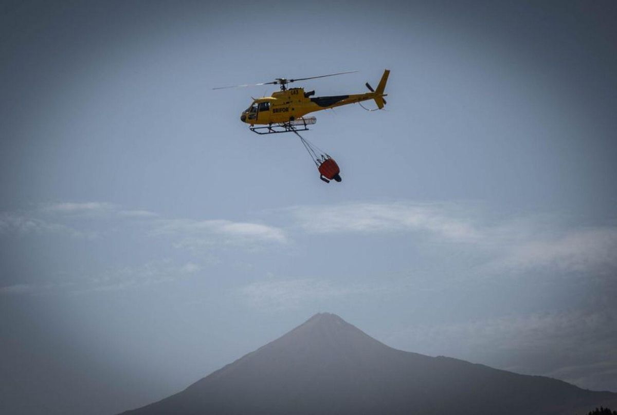 Uno de los helicópteros sobrevuela la zona del incendio. | ANDRÉS GUTIÉRREZ