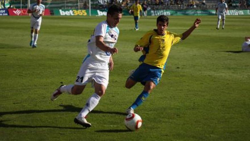 Del Moral, delantero del Caravaca, pugna con un rival del Cádiz por hacerse con el balón.