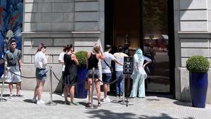 Clientes haciendo cola en la tienda de Louis Vuitton en paseo de Gràcia