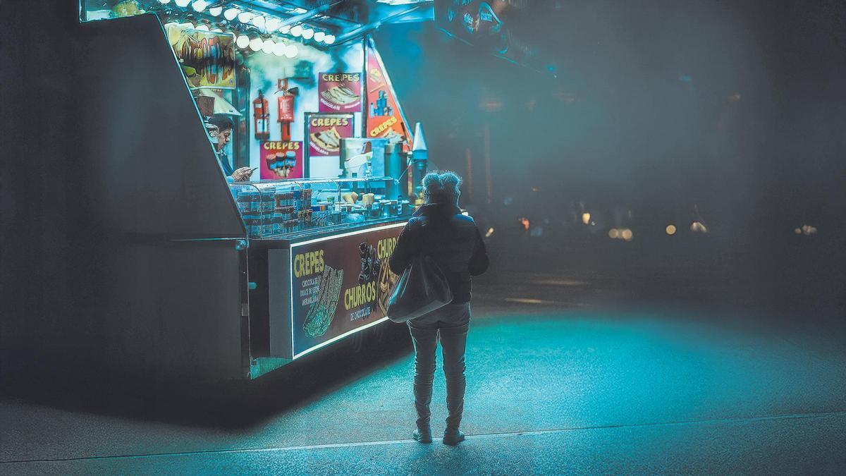 Una señora camina hacia una churrería en Palma