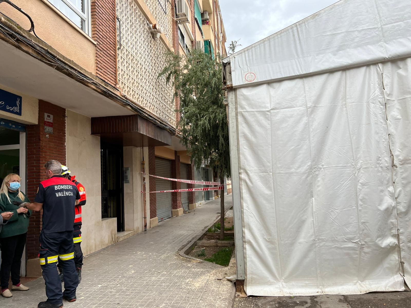 Los cascotes de un edificio caen sobre la carpa de una falla en campanar