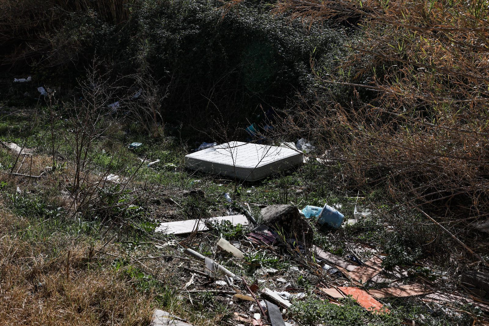 Escombros y basura acumulados junto al río Serpis y las fábricas de la calle Escalò de Alcoy