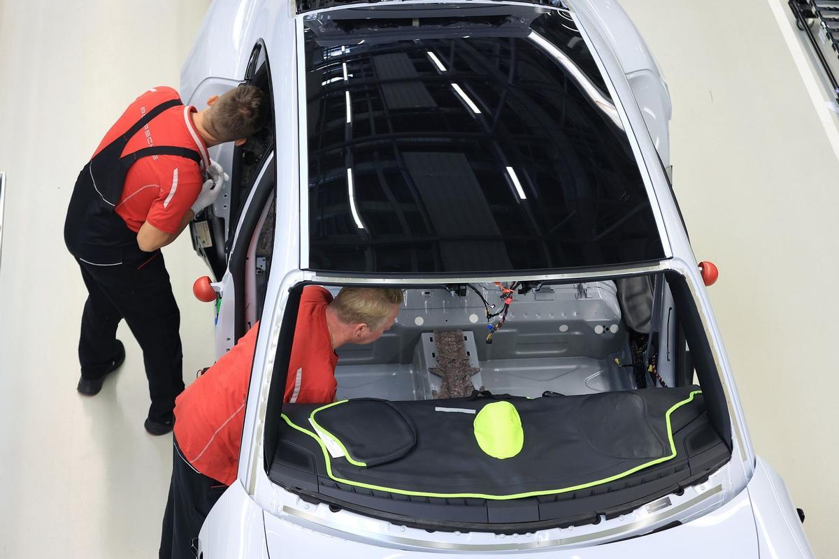 Los empleados trabajan en las carrocerías de los automóviles de lujo Porsche Taycan totalmente eléctricos en la línea de producción de la fábrica de Porsche AG en Stuttgart, Alemania.