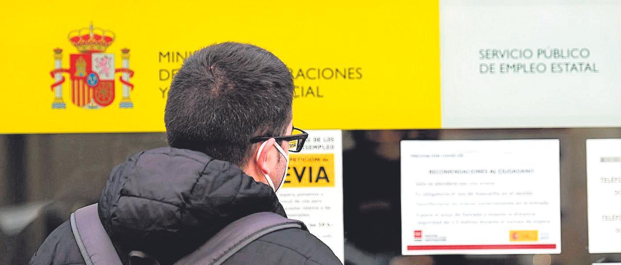 Un hombre consulta carteles informativos en una oficina del Servicio de Empleo.